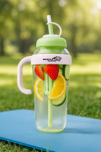 Clear water bottle with fruit infusers on a grassy background